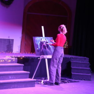 Student painting on stage