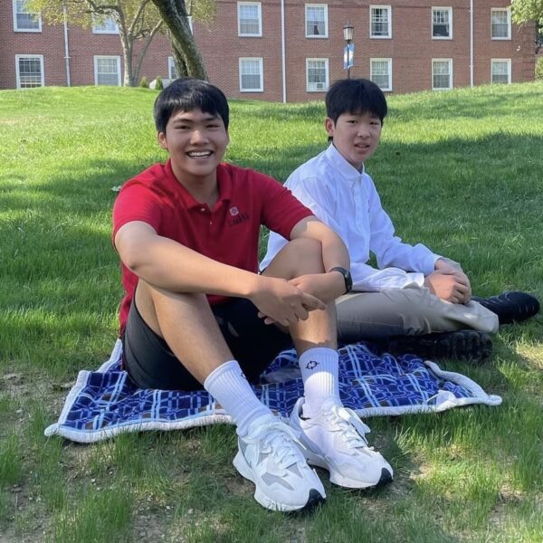 two students sitting on the lawn smiling