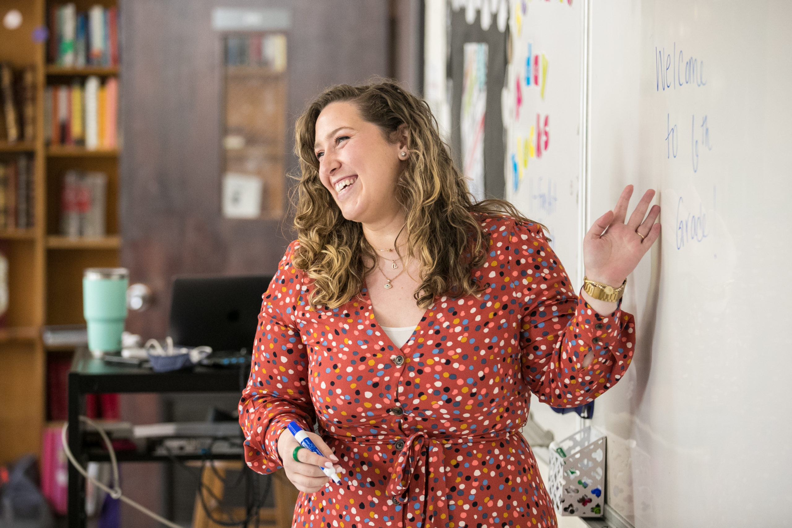 Teacher laughing at the front of the classroom