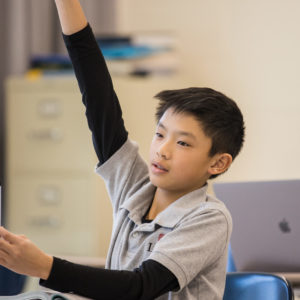 student raising hand in class