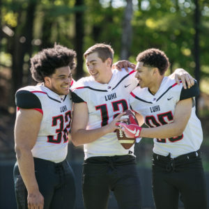 three football players laughing