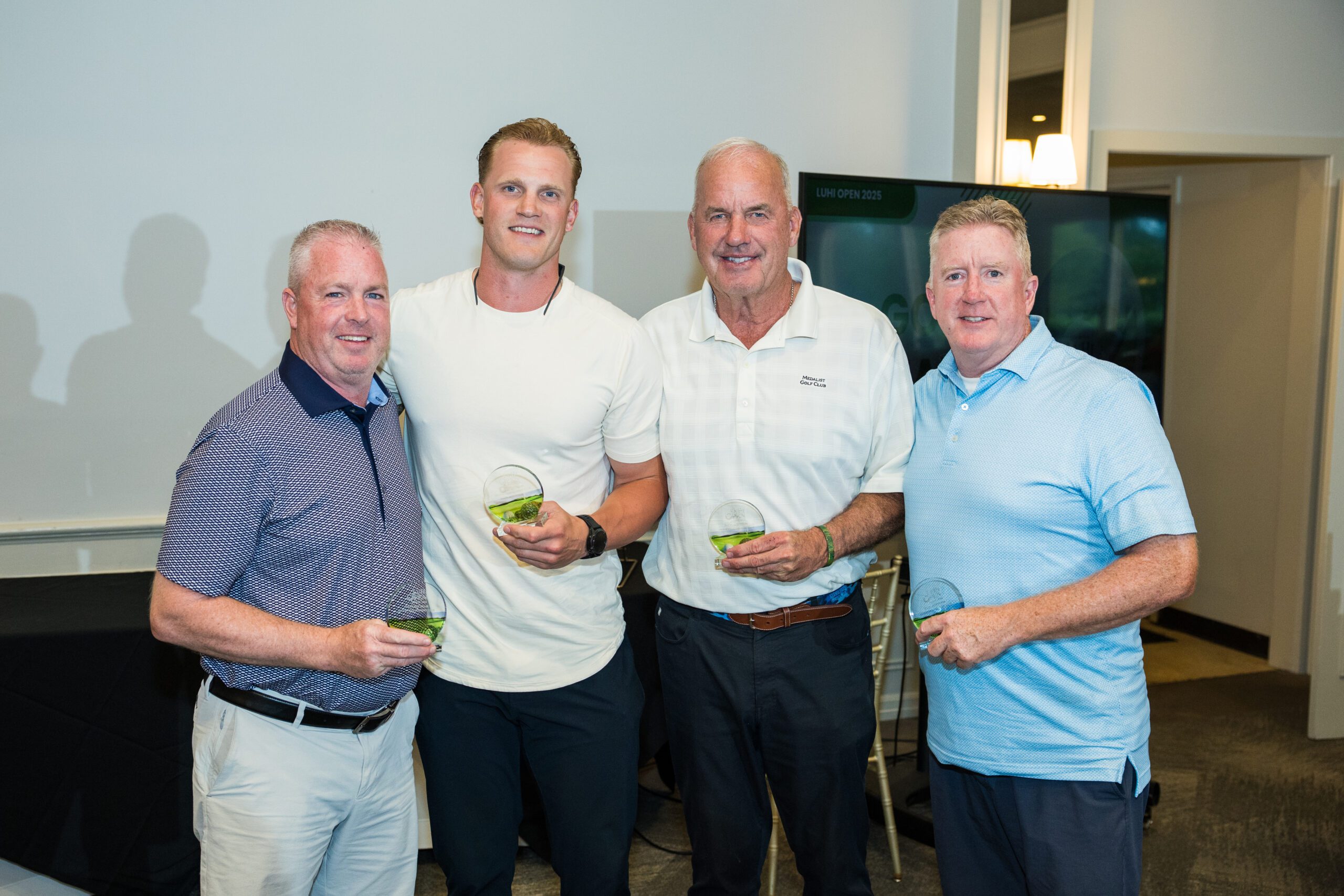 Group of men smiling holding their drinks at the Golf Outing