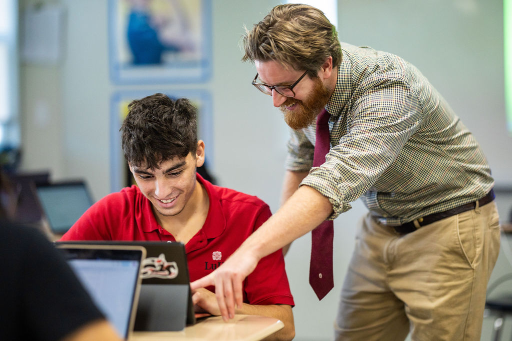 Teacher and student working on computer