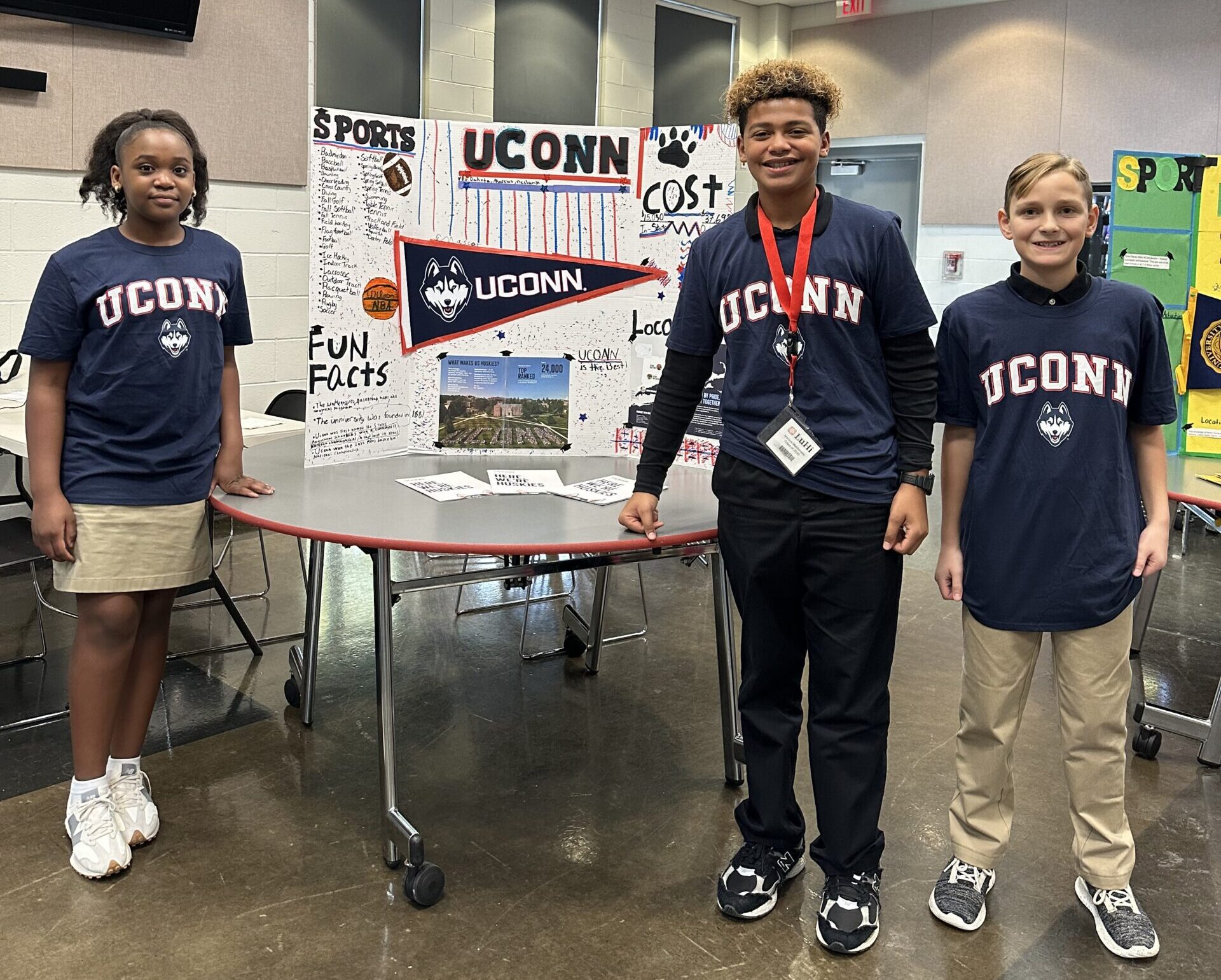 6th grade students showing their presentation board during college fair