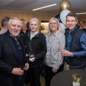 Group of four people posing for picture at event